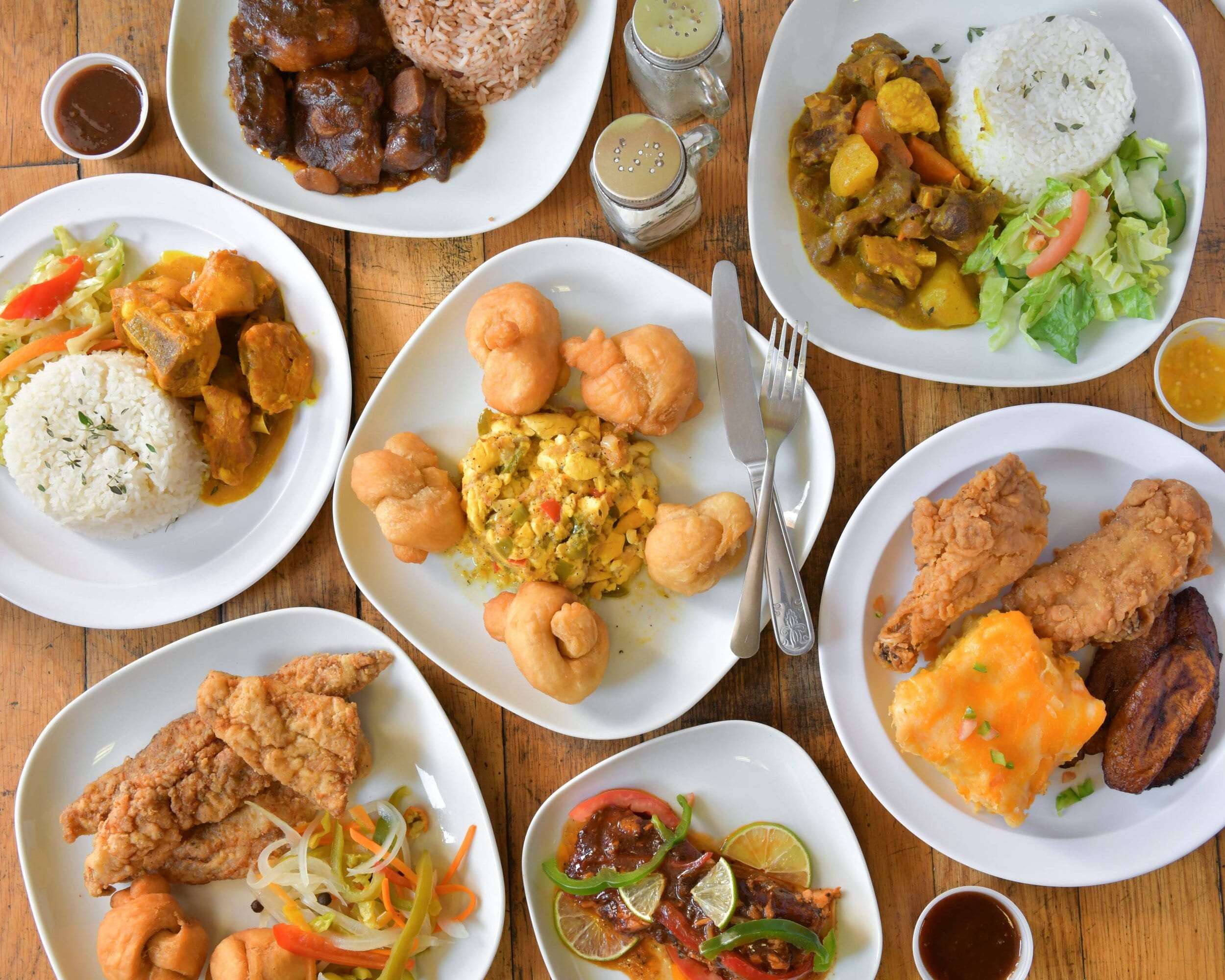Authentic Jamaican food spread featuring jerk chicken, rice and peas, and plantain